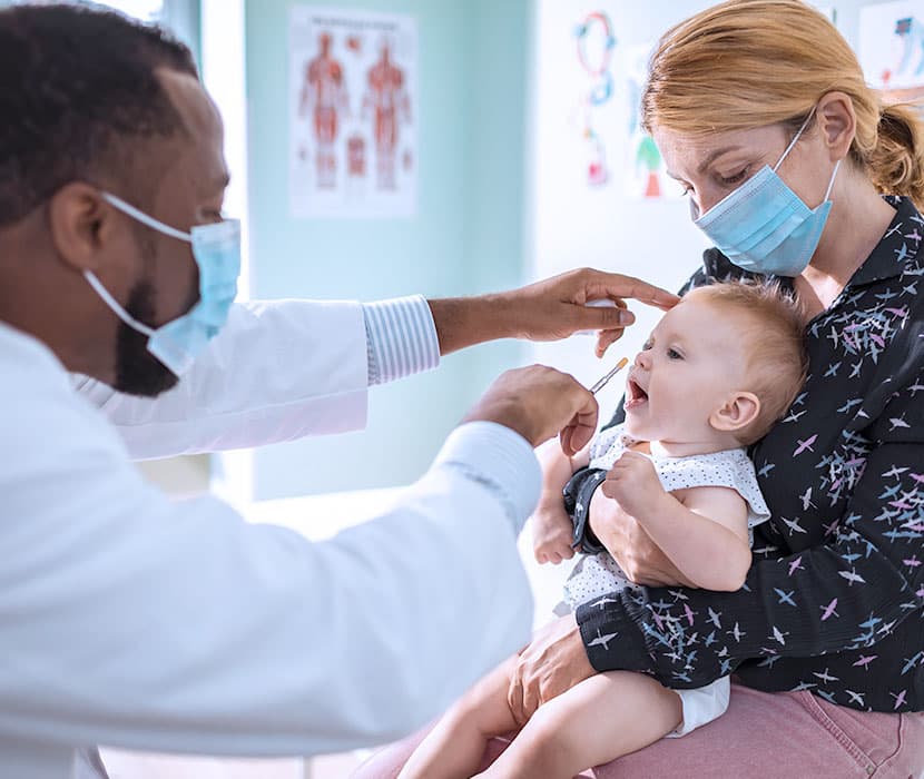 A baby getting a check up at the doctors office.