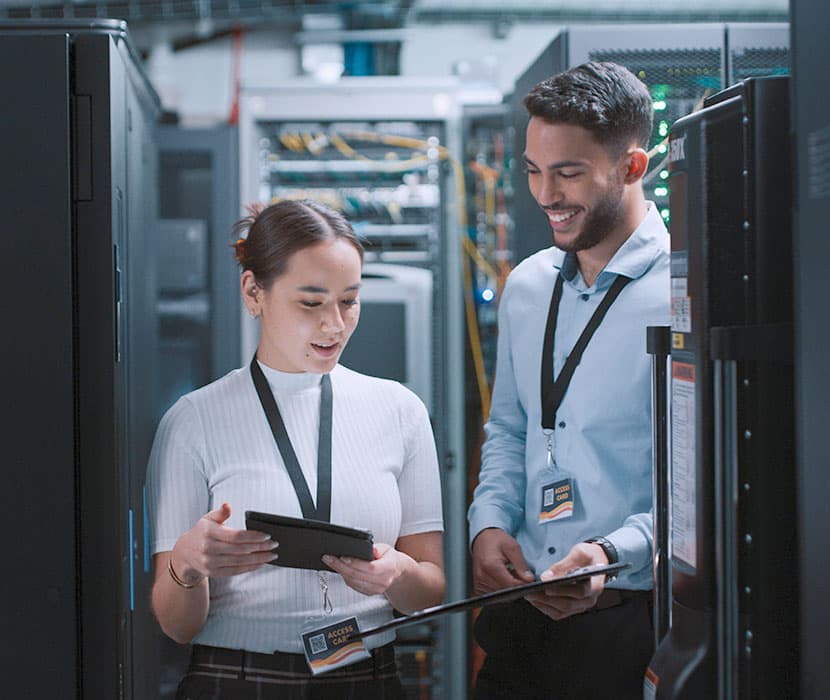 Two co-workers working together in the server room.